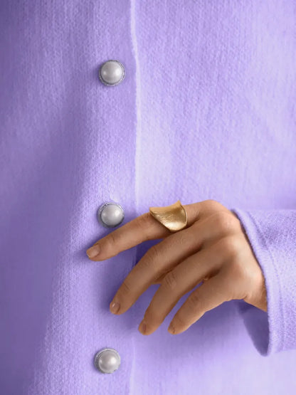 Lavina Cardigan by Lauven in lilac with pearl button closure and stylish hand wearing gold ring.