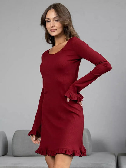 Model wearing a sultry crimson red long sleeve dress with ruffled cuffs and hem, showcasing a flattering silhouette.