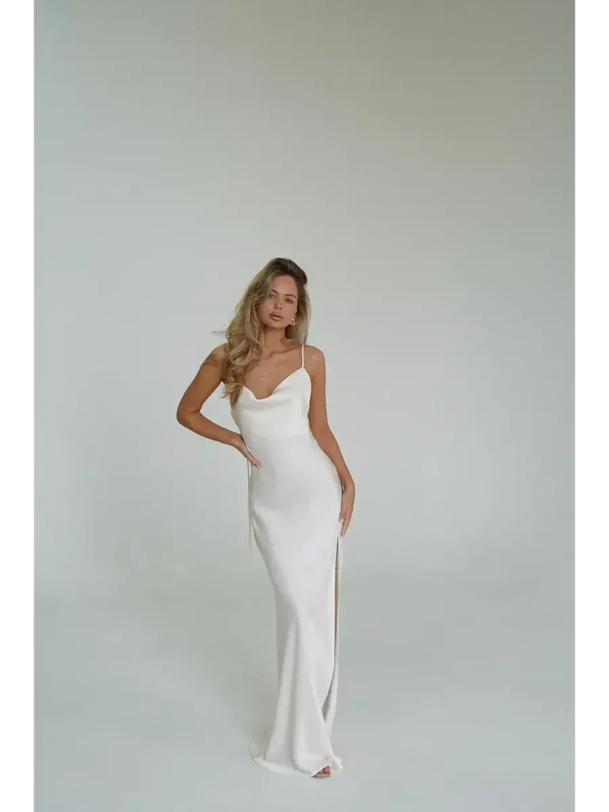 Model wearing the Ivory Luxe Maxi Dress, showcasing its silky drape and high side slit against a neutral background.