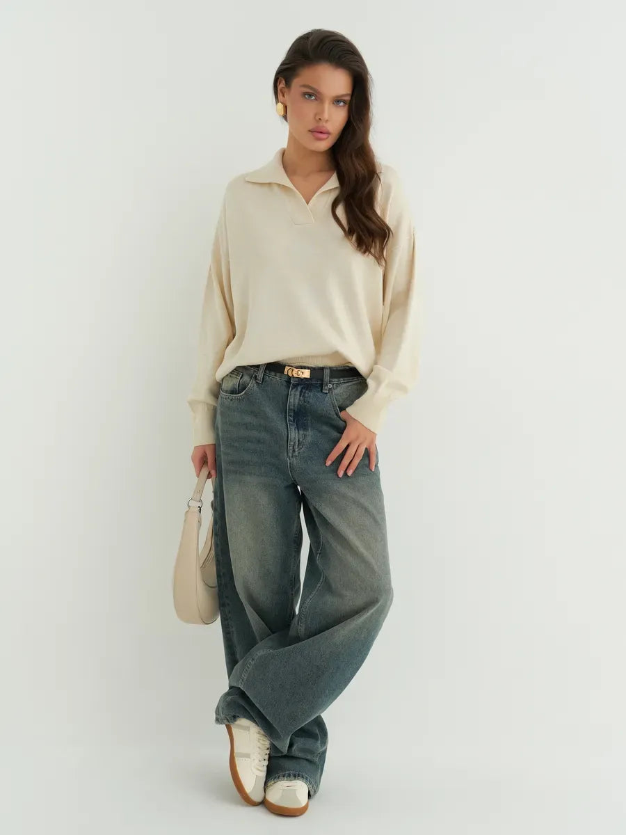 Stylish model wearing a Lauven Linen Sweater, oversized light beige knit, paired with wide-legged jeans.