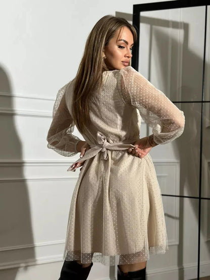 Liora Mini Dress by Lauven, showing elegant ivory chiffon with sheer polka dot sleeves and a stylish tied waist.