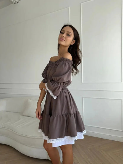 Model showcasing the Mocha Muse off-shoulder mini dress with white ruffle trim in a bright indoor setting.
