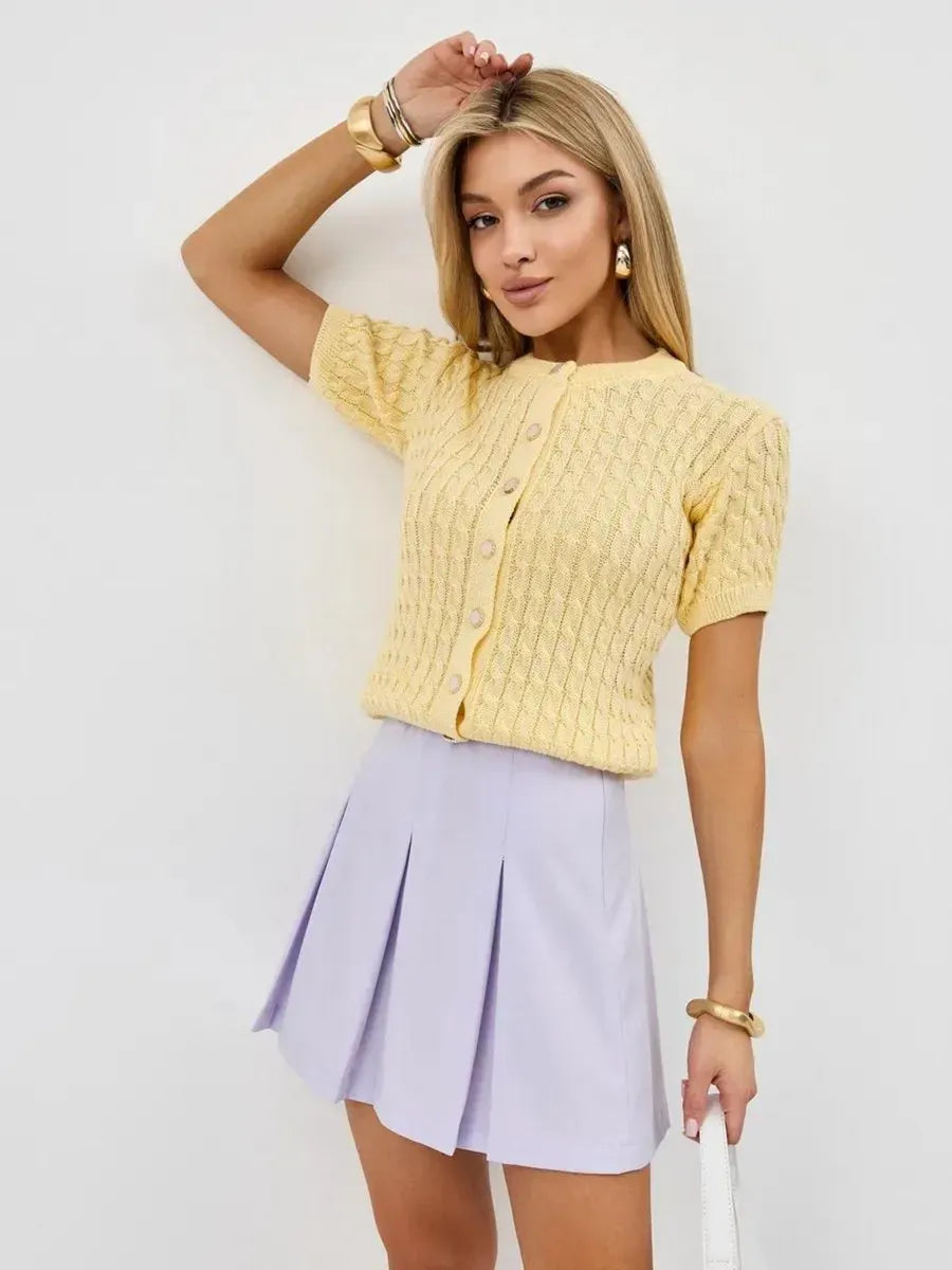 Model wearing Solara Cardigan by Lauven in soft yellow with pleated lilac skirt, showcasing summer style.