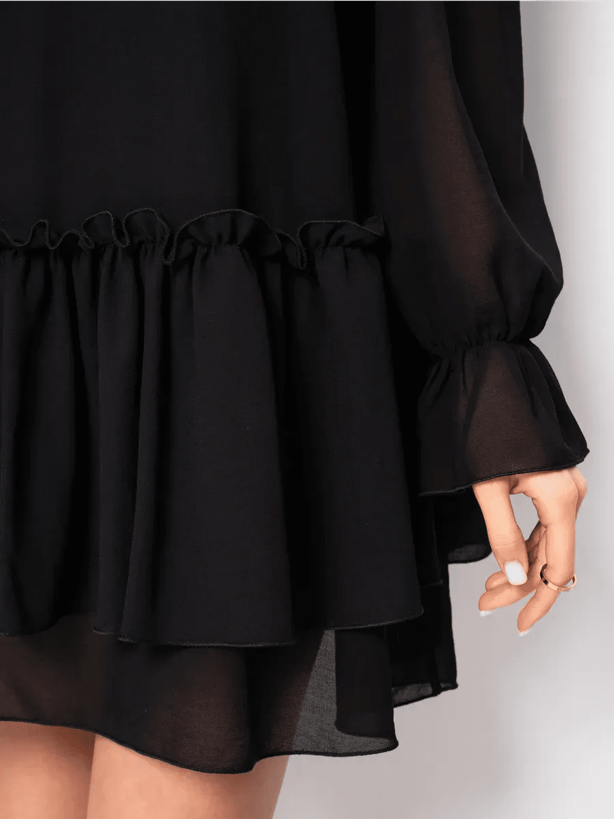 Detail of the Noirelle Mini Dress by Lauven, showcasing ruffled layers and elegant black chiffon fabric.