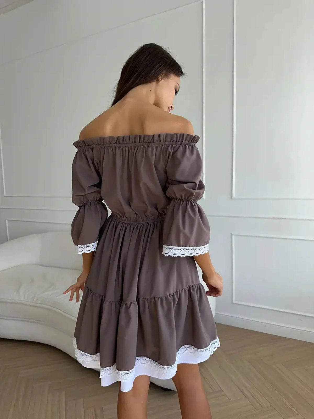 Back view of the Mocha Muse off-shoulder mini dress featuring ruffle trim and a flattering A-line silhouette.