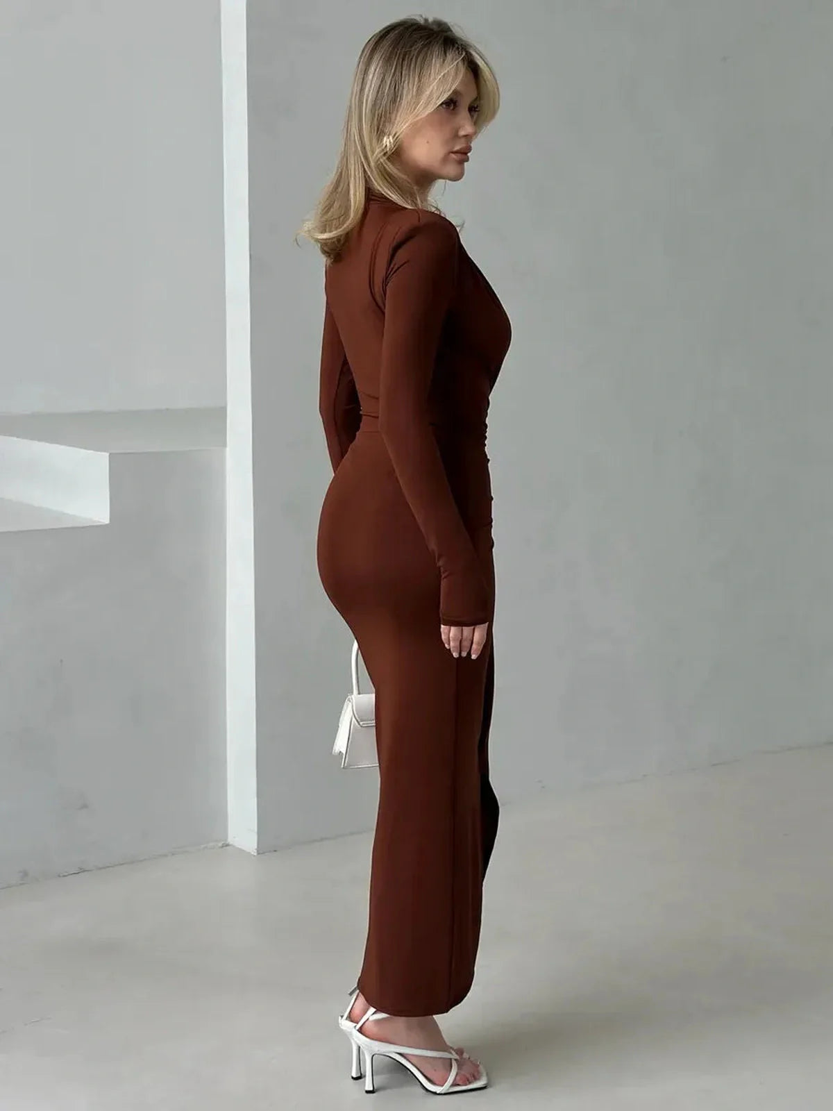 Sienna Plunge Maxi Dress in rich sienna hue, showcasing a sculpted silhouette and dramatic plunge neckline from a side view.