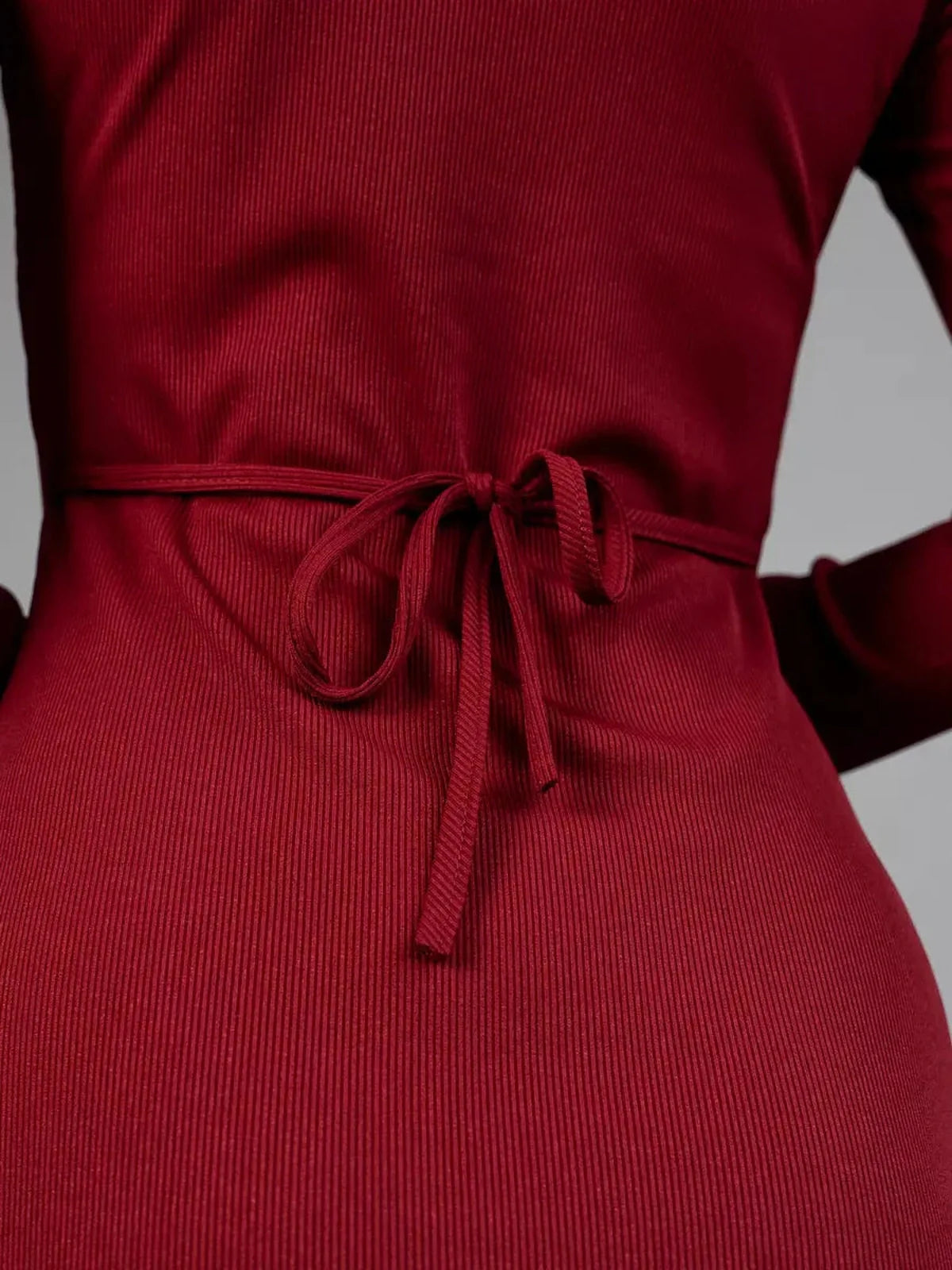 Close-up of the adjustable lace-up back detail on a sultry red dress emphasizing elegance.