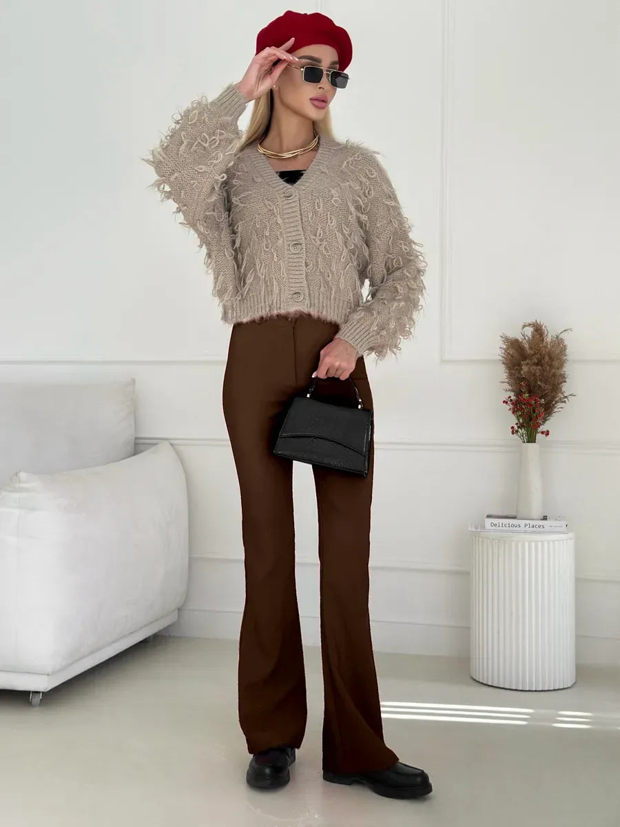 Sahara Cardigan by Lauven, cropped oversized beige bouclé knit with feathered fringe and stylish brown pants.