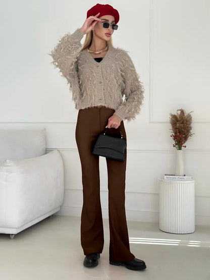 Sahara Cardigan by Lauven, cropped oversized beige bouclé knit with feathered fringe and stylish brown pants.