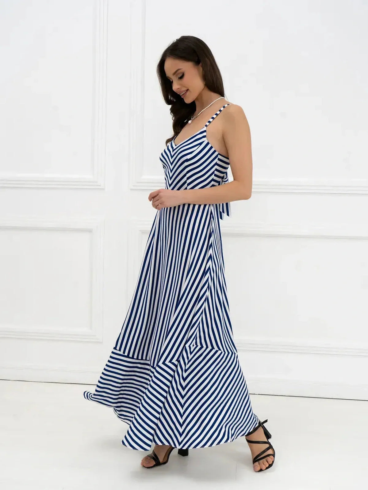 Marina Stripe Maxi Dress in navy and white stripes, featuring a flowing silhouette and open-back bow detail.