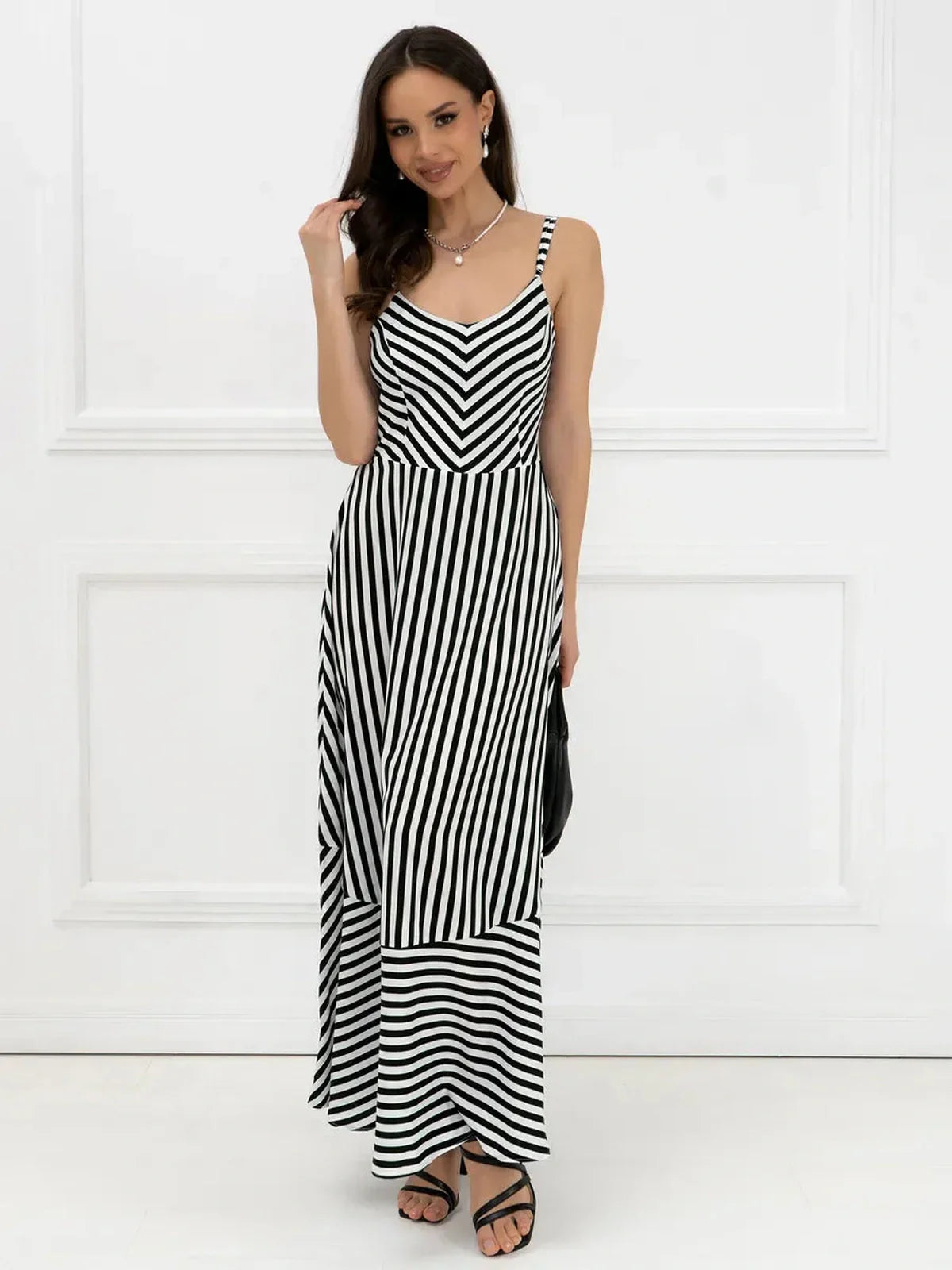 Black and white striped maxi dress with fitted bodice and flowing silhouette, perfect for elegant summer style.