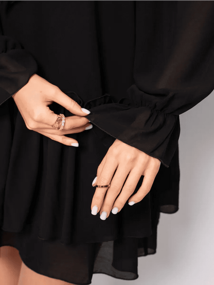 Close-up of hands showcasing ruffled sleeves on the Noirelle Mini Dress by Lauven, featuring elegant black chiffon.