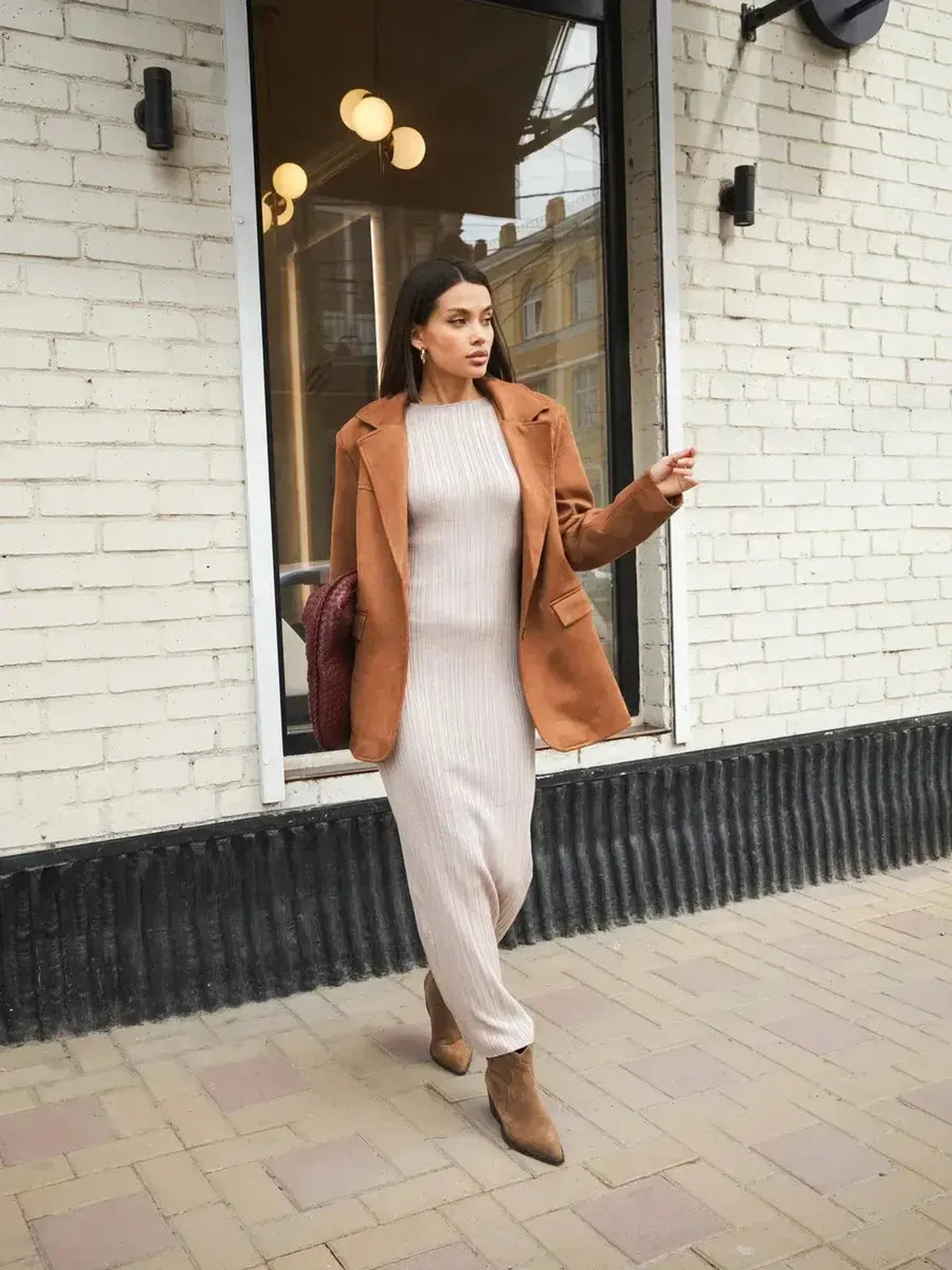 Woman in a Contour Knit Maxi Dress with a brown jacket, showcasing refined style and sophistication.