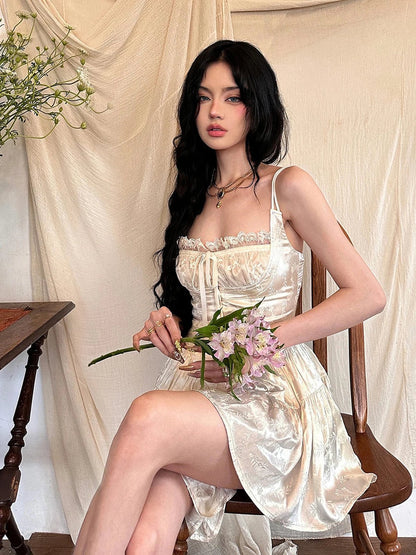 Model wearing the Ivy Mini Dress, a vintage-inspired white dress with lace detailing, holding flowers.