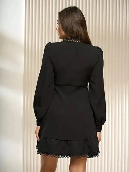 Back view of a black mini dress with lace trim and long sleeves, perfect for formal events or cocktail parties.