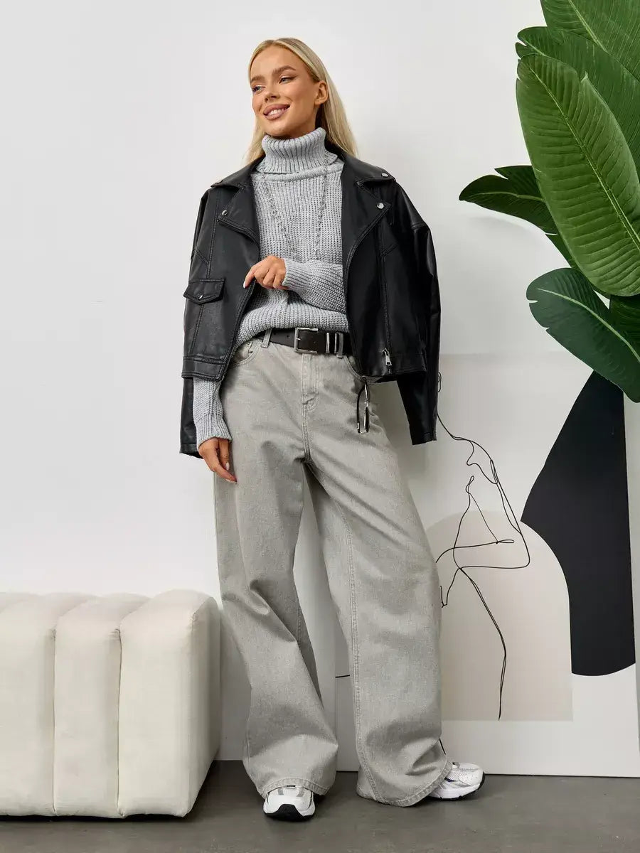 Astra Sweater from Lauven styled with a black leather jacket and wide-leg trousers in a chic indoor setting.