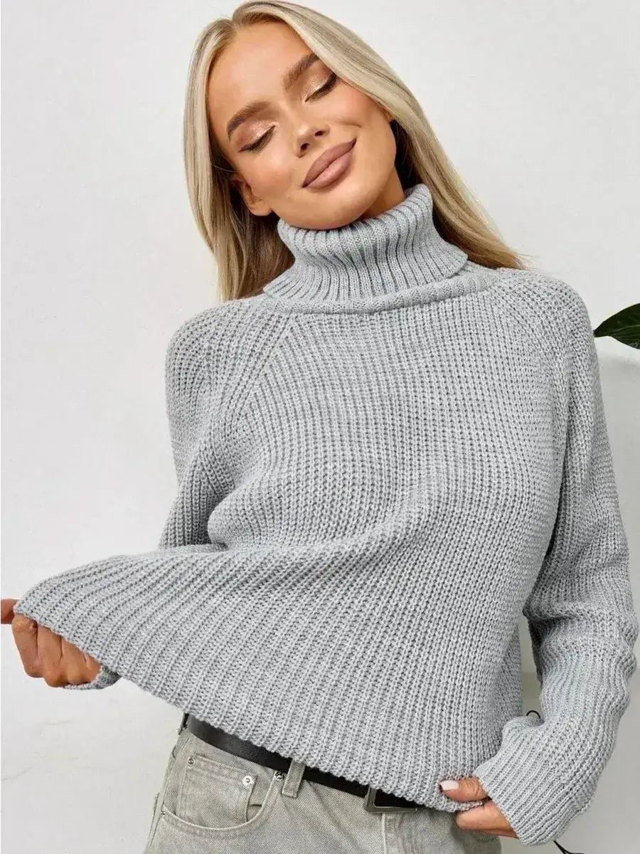 A woman wearing the Astra Sweater, an oversized grey knit with a turtleneck, showcasing comfort and style from Lauven.