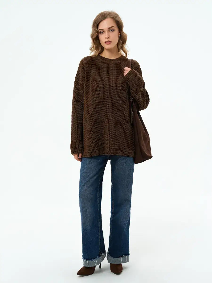 Model wearing the Atlas Sweater by Lauven, an oversized knit in rich brown, styled with flared jeans.