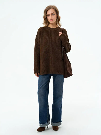 Model wearing the Atlas Sweater by Lauven, an oversized knit in rich brown, styled with flared jeans.