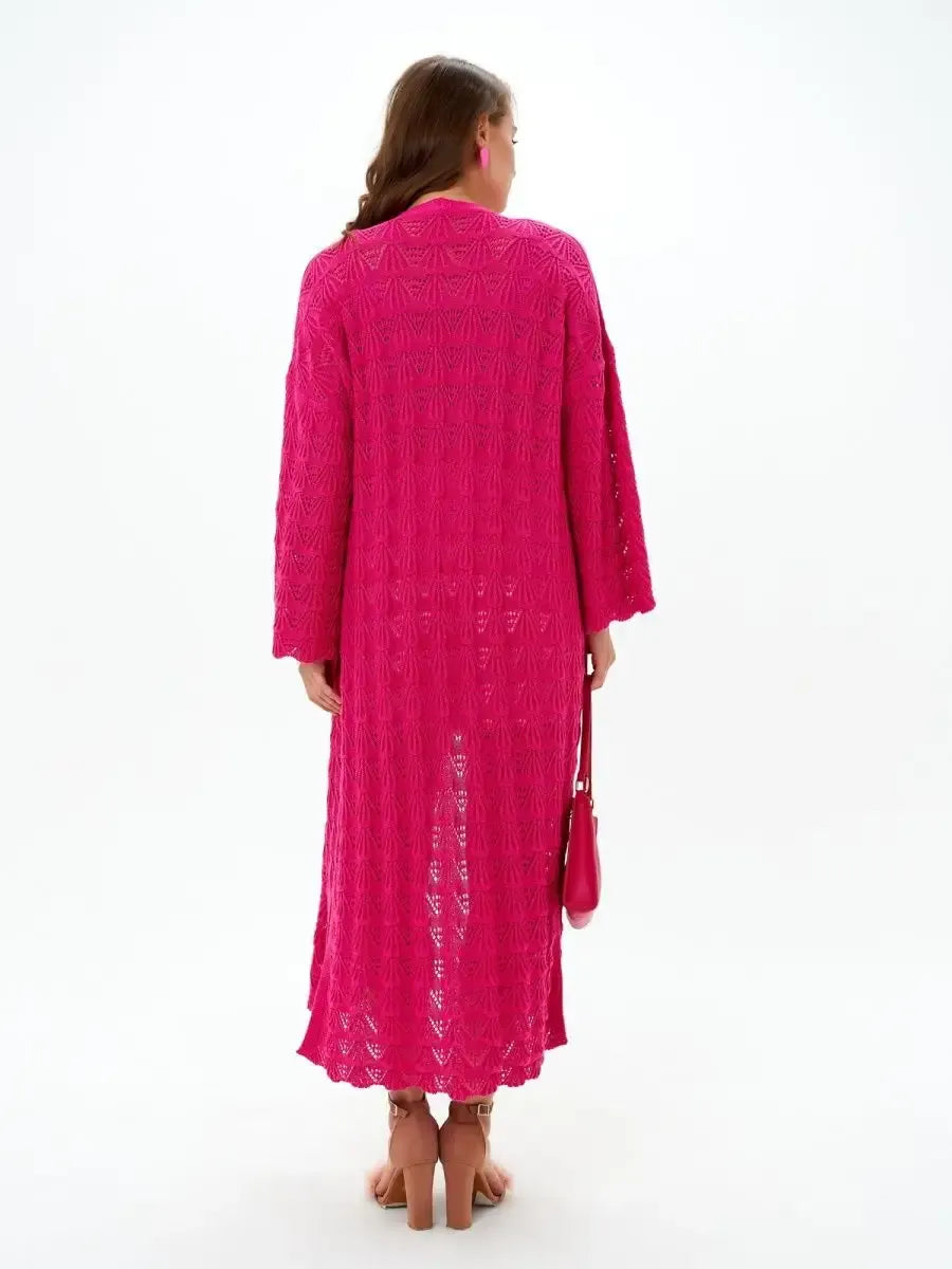 Back view of a woman wearing a vibrant raspberry Berry Cardigan by Lauven, showcasing its openwork knit design.