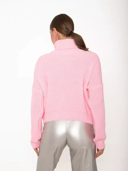 Back view of a woman wearing the Blossom Pullover from Lauven, an oversized light pink knit sweater with high neck.