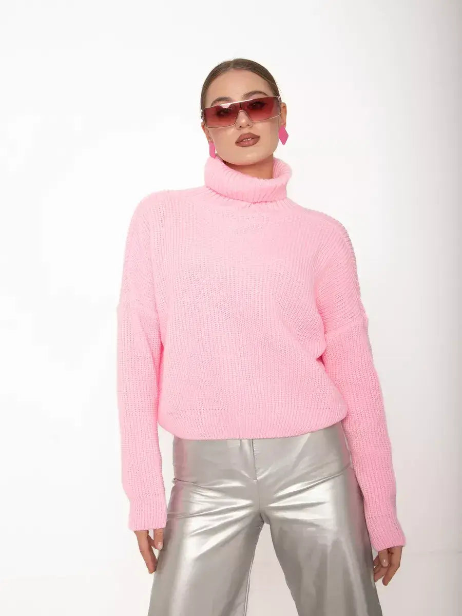 Lauven Blossom Pullover in oversized light pink knit with high neck, styled with silver pants and sunglasses.