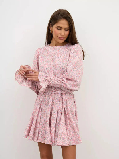 Lauven Blush Bloom Mini Dress in soft pink floral print, featuring long sleeves, round neck, and flared skirt.