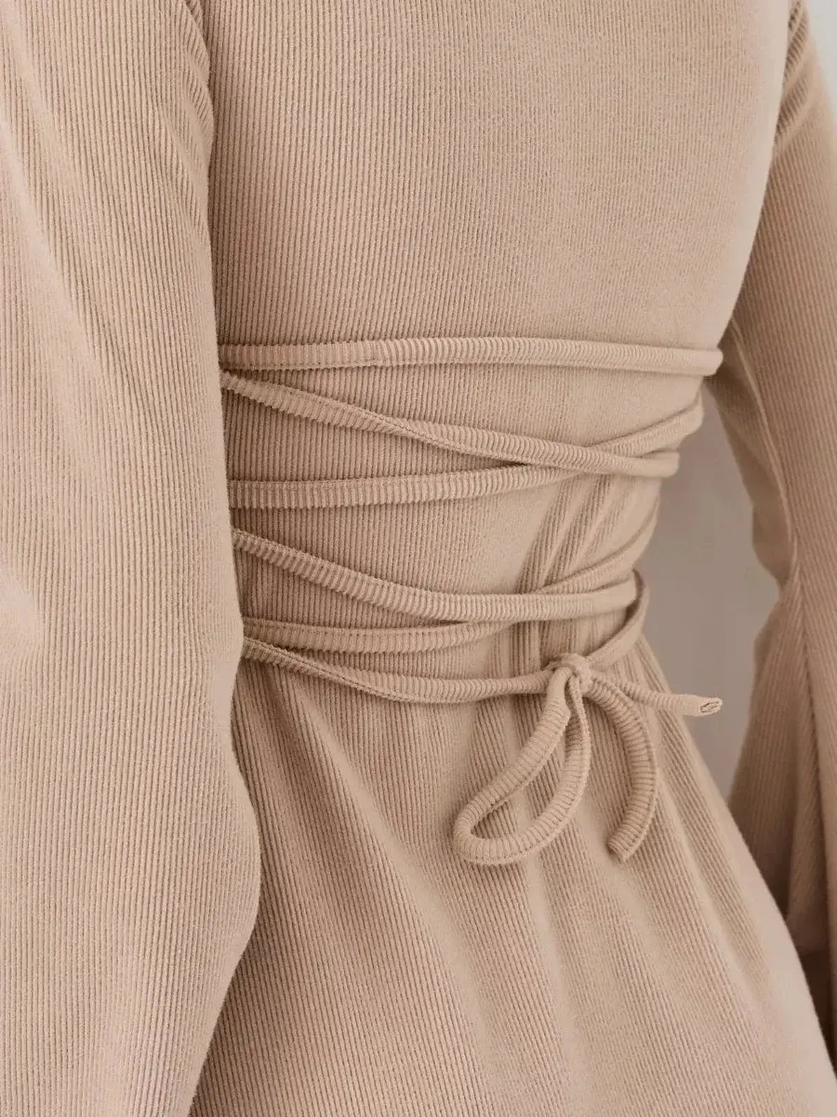 Close-up of the back detail of the Café Ribbon mini dress by Lauven, showcasing its ribbed texture and tie design.