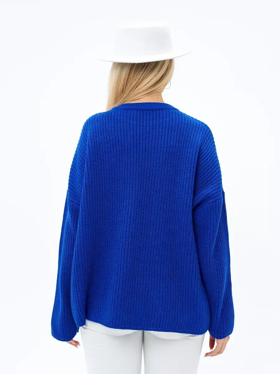 Back view of a woman wearing the Lauven Capri Sweater in electric blue with oversized knit design.