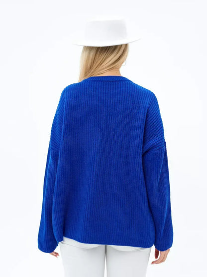 Back view of a woman wearing the Lauven Capri Sweater in electric blue with oversized knit design.