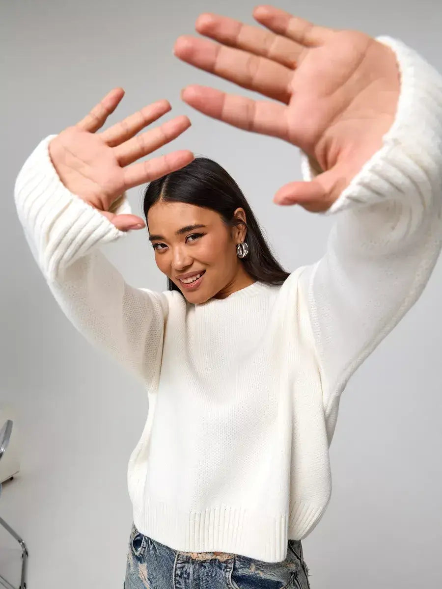 Celeste Pullover by Lauven - oversized cropped women's sweater in soft ivory worn by a smiling woman.