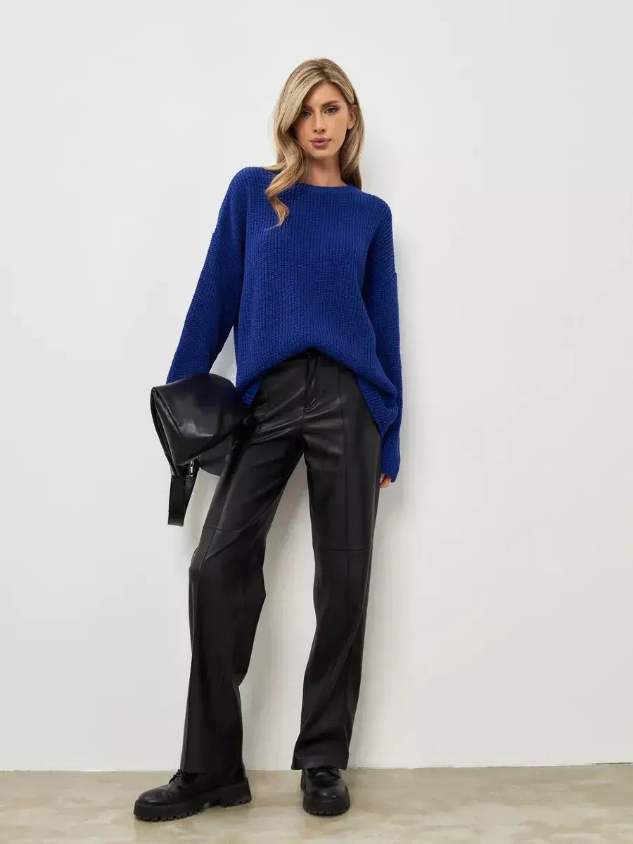 Model wearing the Celeste Sweater by Lauven in electric blue, paired with black leather pants, showcasing a relaxed style.