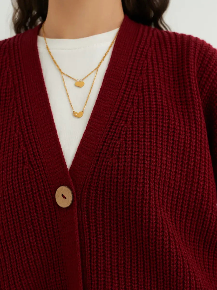 Close-up of the Cherry Cardigan by Lauven, featuring deep cherry red knit and stylish layered necklaces.