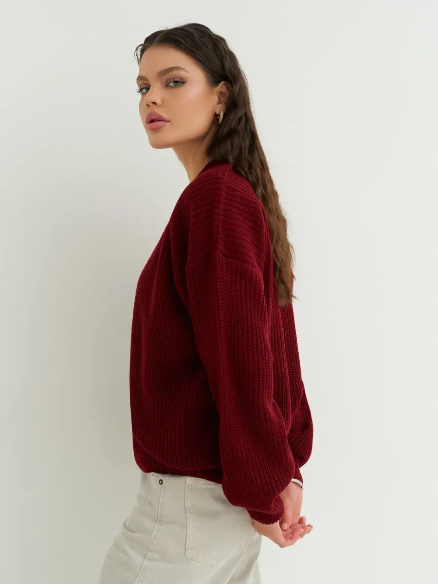 Model showcasing the Cherry Cardigan by Lauven in deep cherry red, highlighting cozy oversized knitwear style.