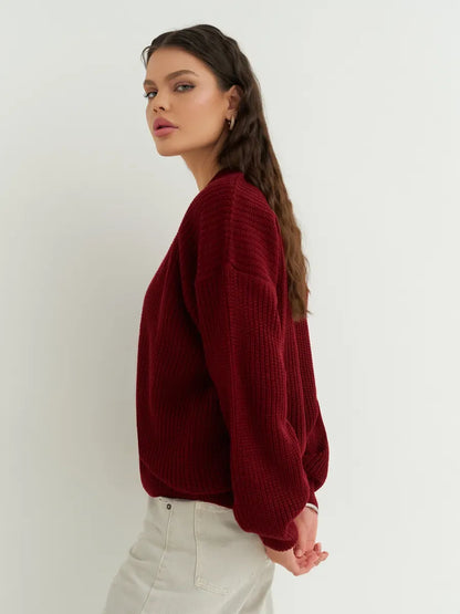 Model showcasing the Cherry Cardigan by Lauven in deep cherry red, highlighting cozy oversized knitwear style.