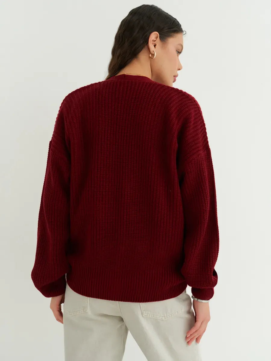 Back view of a woman wearing a Lauven Cherry Cardigan in deep cherry red, showcasing its oversized and cozy design.