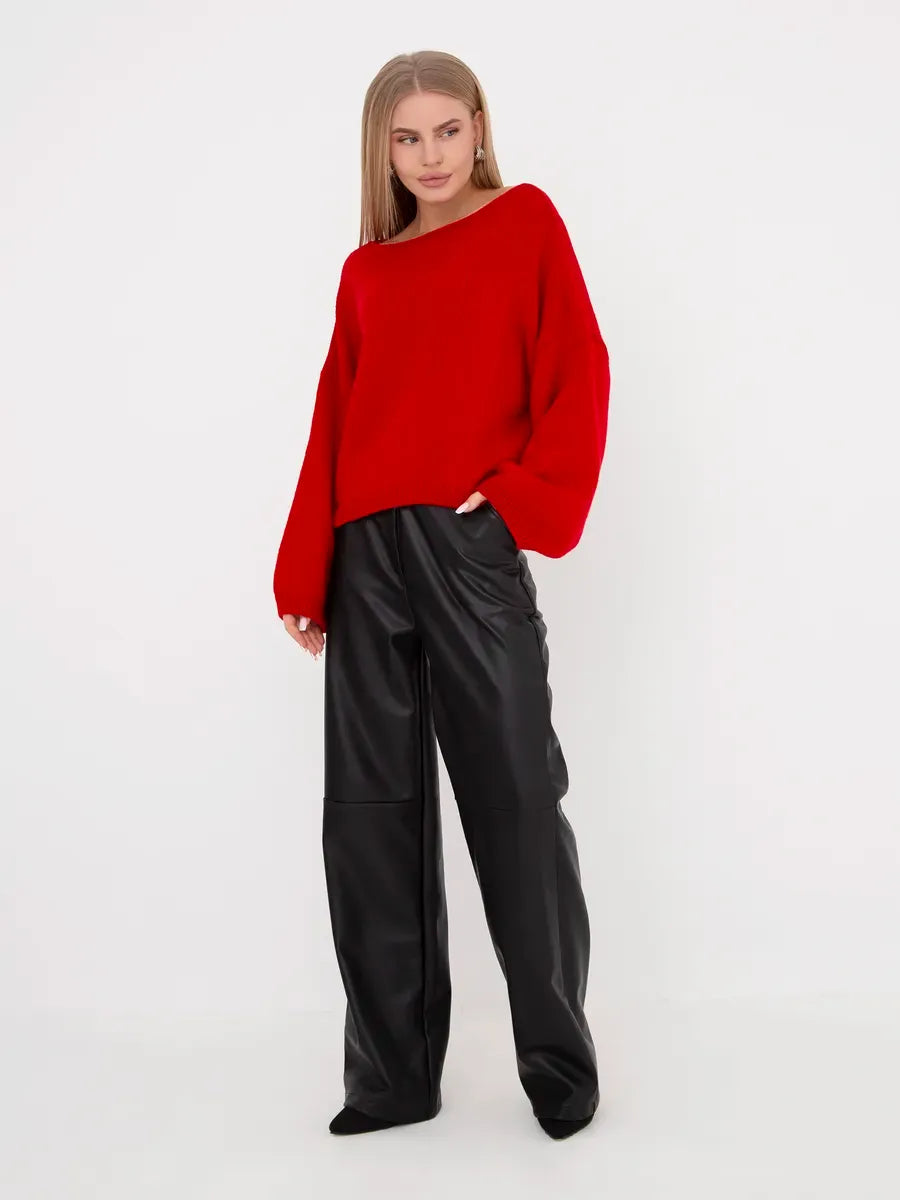 Model wearing a Crimson Sweater by Lauven, featuring an oversized fit and a boat neckline, paired with black leather pants.