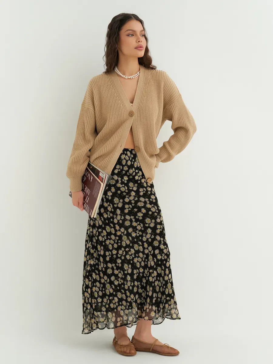 Dune Cardigan by Lauven styled with a floral skirt, showcasing its oversized fit and chic design in dark beige.