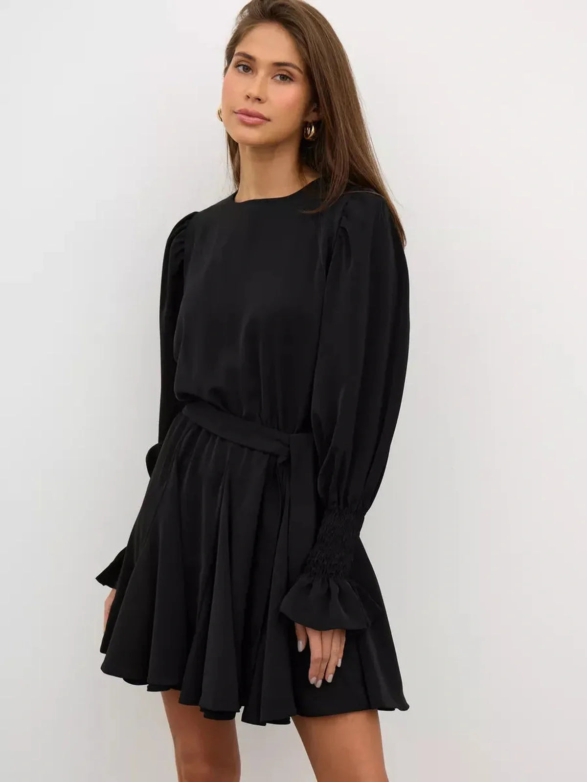 Model wearing the Lauven Eclipse Mini Dress in black polyester, featuring long sleeves and a ruffled hem.