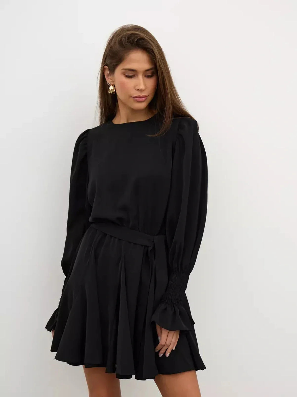 Lauven Eclipse Mini Dress in black, featuring long sleeves, ruffled hem, and fitted waist for elegant day-to-night style.