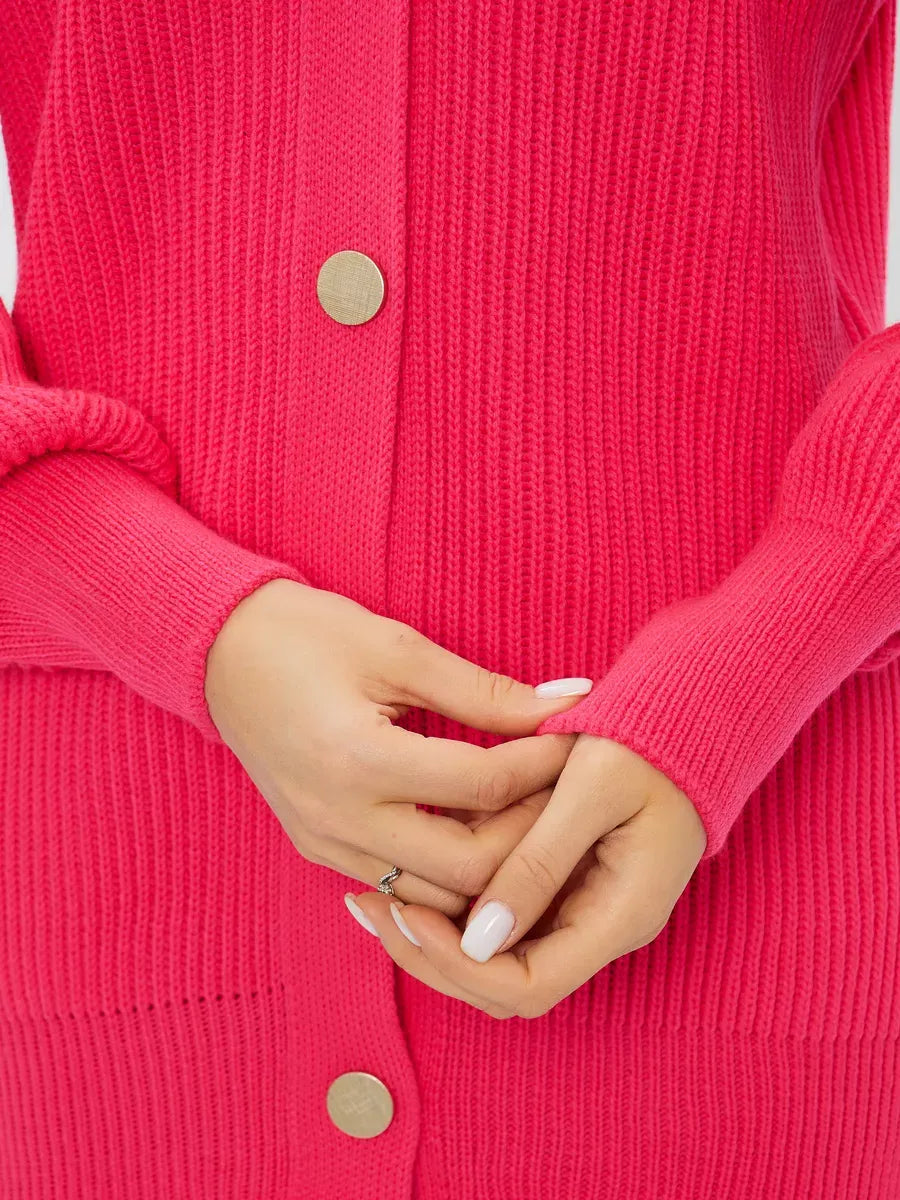 Close-up of hands holding the Fuchsia Cardigan by Lauven, showcasing its vibrant pink color and button details.