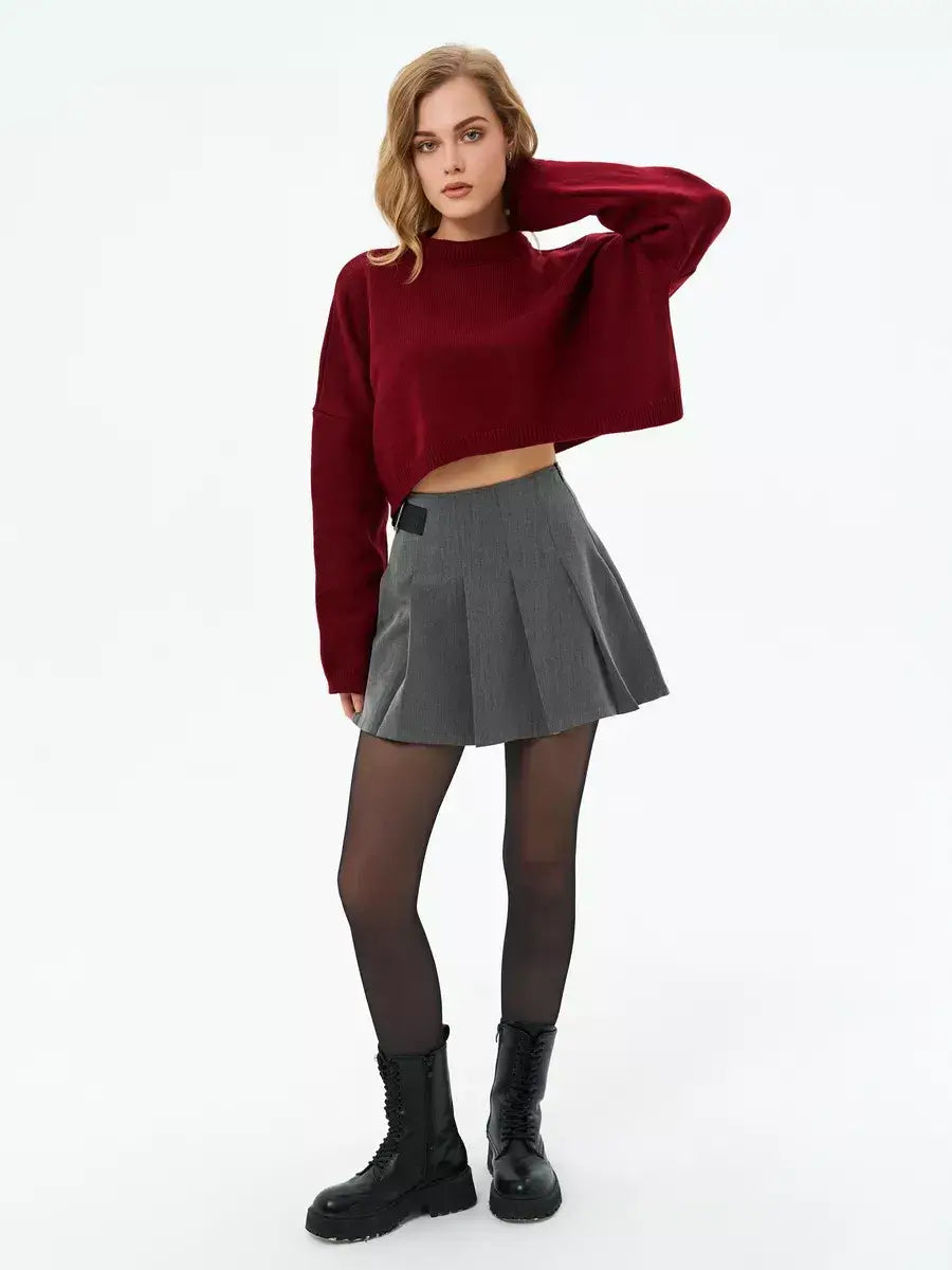 Garnet Sweater by Lauven in deep burgundy, cropped oversized knit paired with a gray pleated skirt.