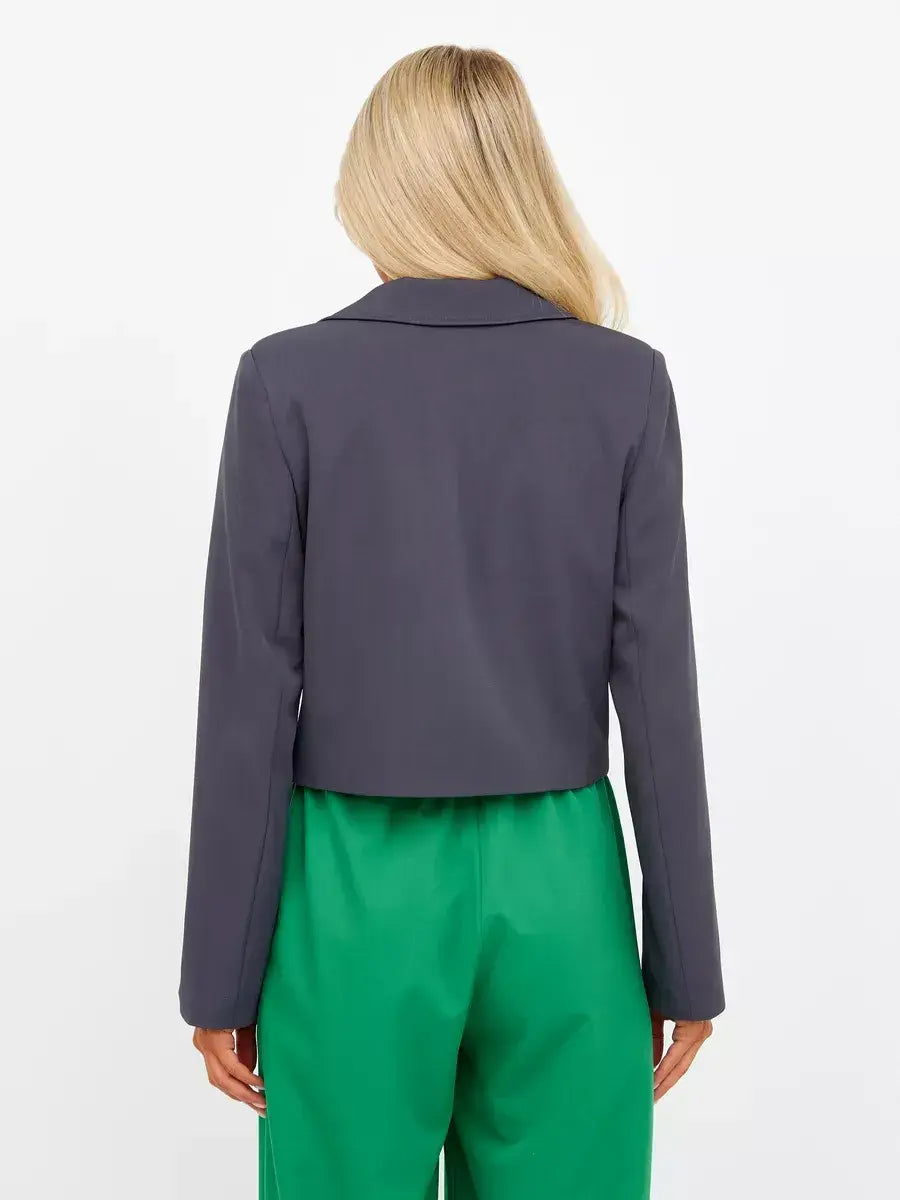 Back view of a woman wearing a Graphite Blazer from Lauven, featuring a cropped tailored design in dark gray.