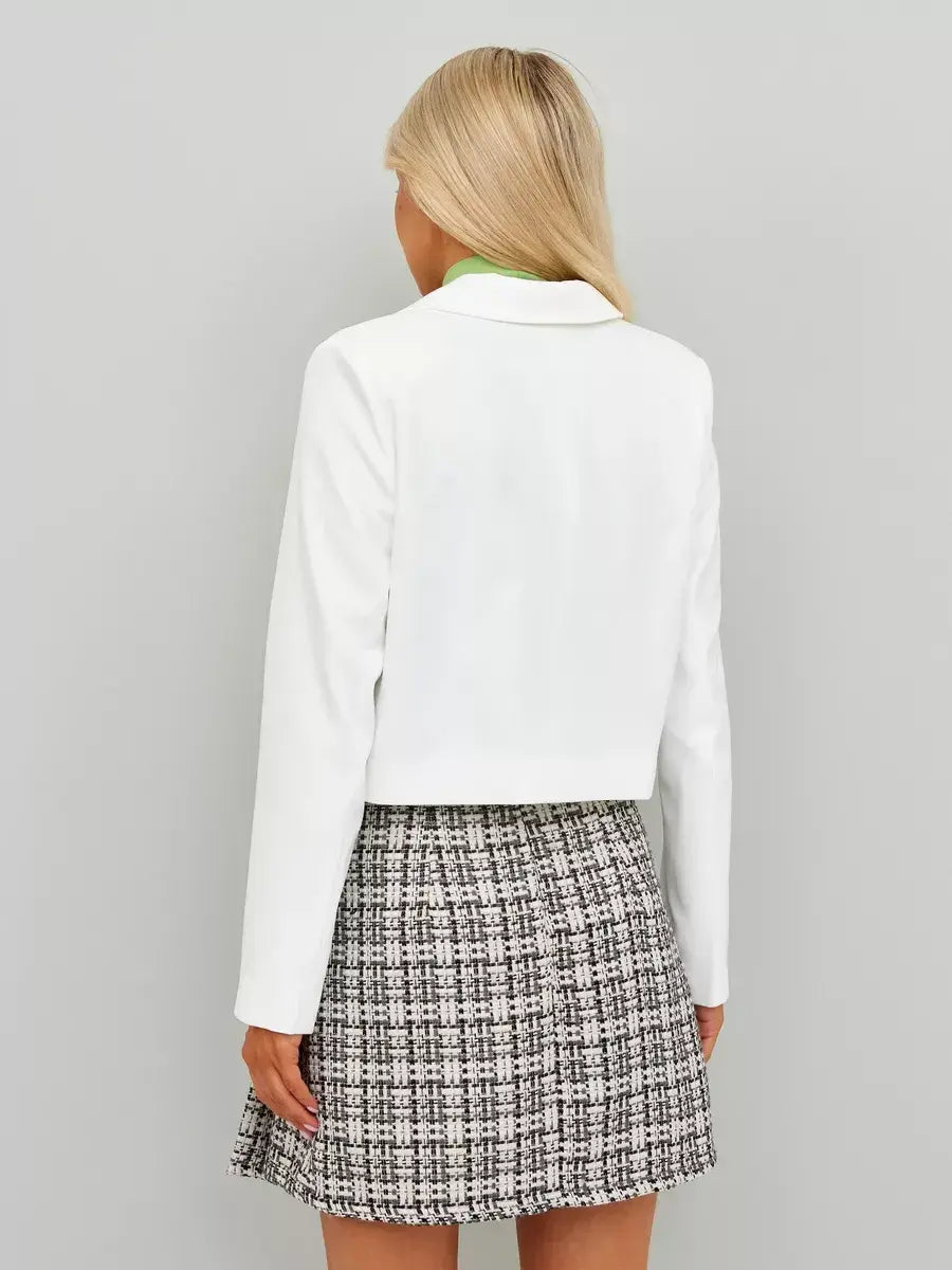Back view of a model wearing a Lauven Ivory Blazer paired with a patterned skirt, showcasing classic cropped elegance.