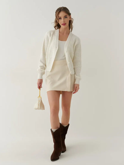 Luna Cardigan by Lauven, oversized cropped knitwear in cream, styled chicly with a skirt and knee-high boots.