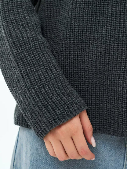 Close-up of a hand wearing the Lauven Luna Sweater, showcasing the textured knit in charcoal gray.