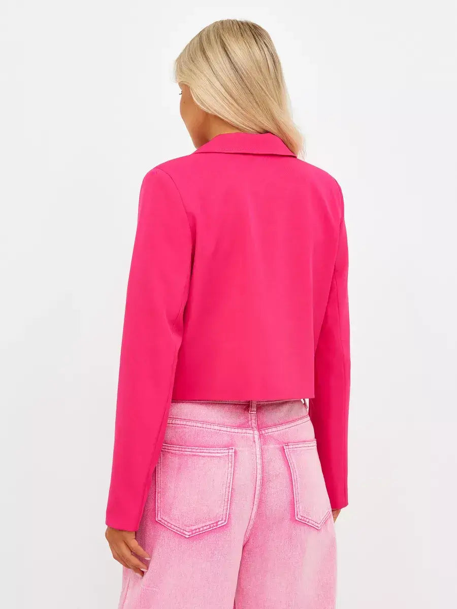 Back view of a woman wearing a cropped Magenta Blazer from Lauven, showcasing its vibrant pink color and tailored design.