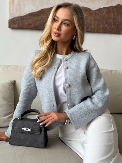 Model showcasing the Lauven Marin Cardigan, an elegant light gray cropped knitwear with button closure.