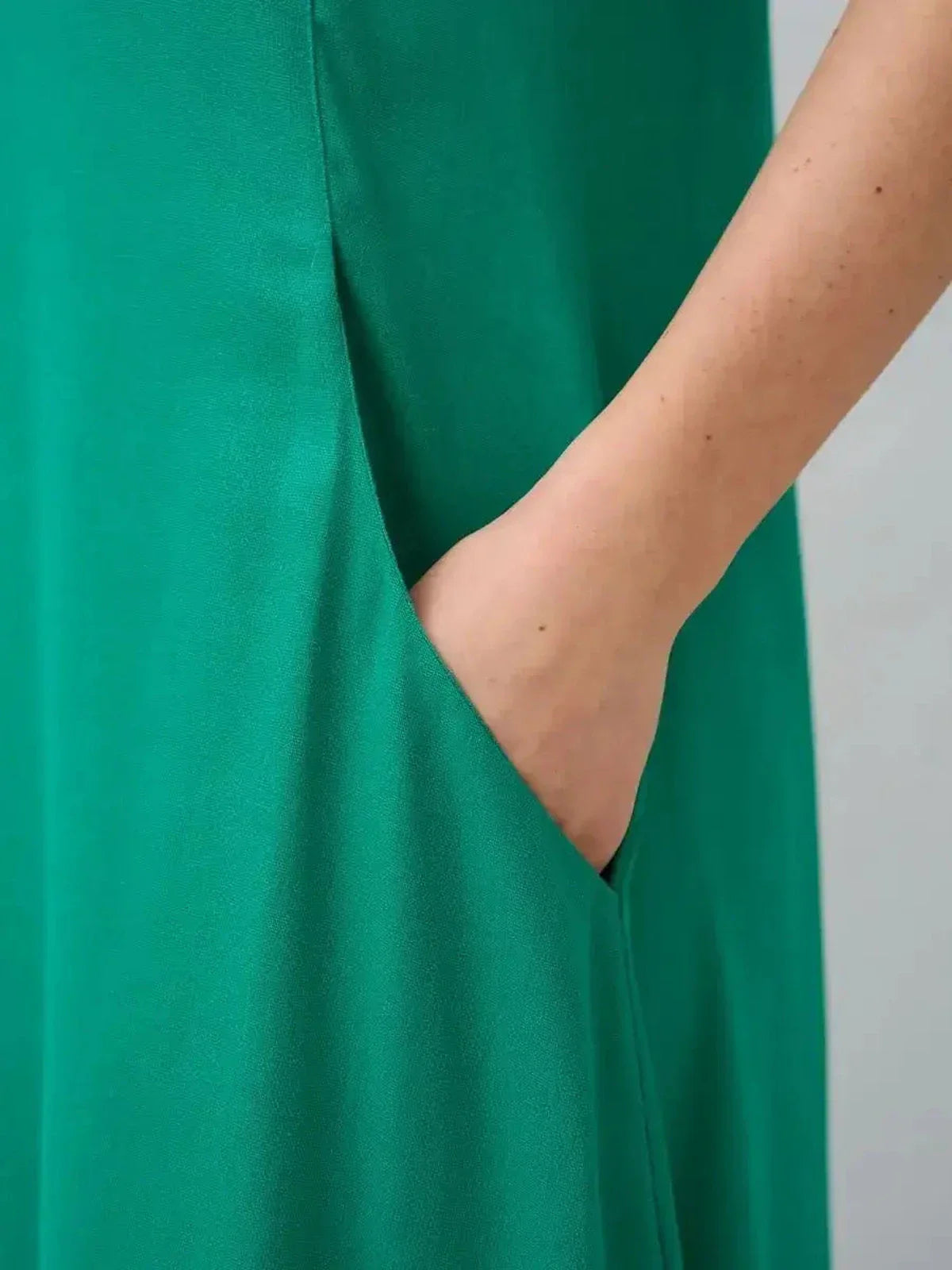 Close-up of a green maxi dress showcasing a hidden side pocket for added functionality and style.