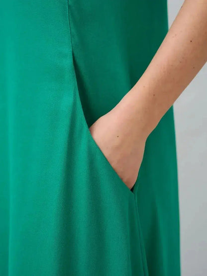 Close-up of a green maxi dress showcasing a hidden side pocket for added functionality and style.